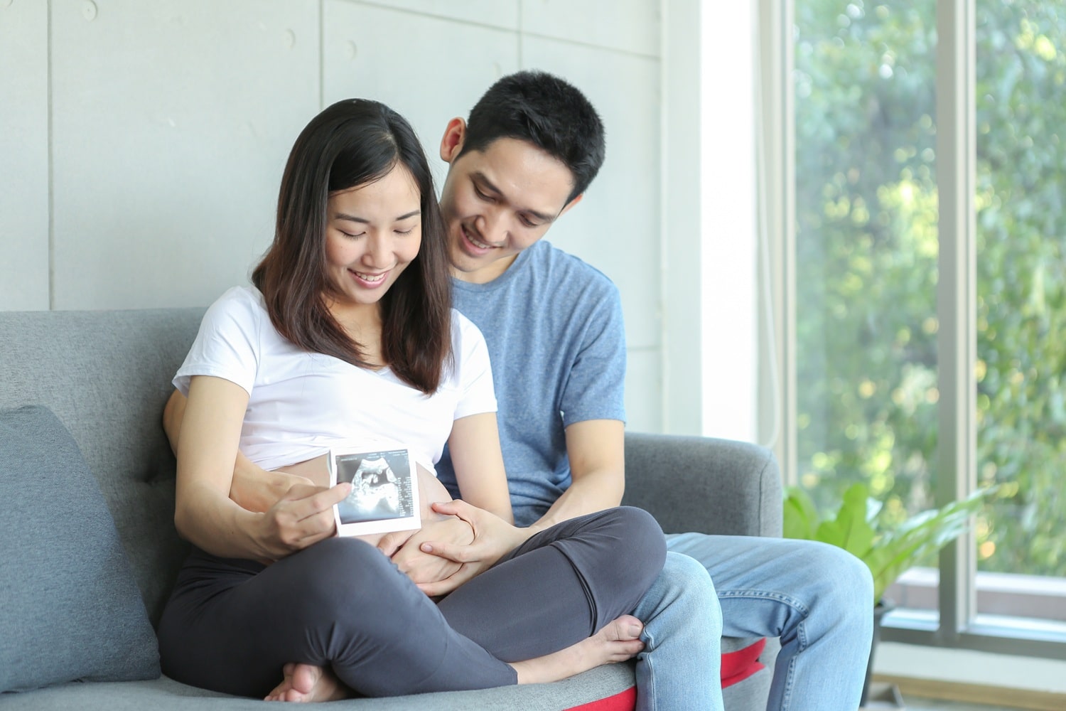 Pasangan suami istri berpose dengan usg